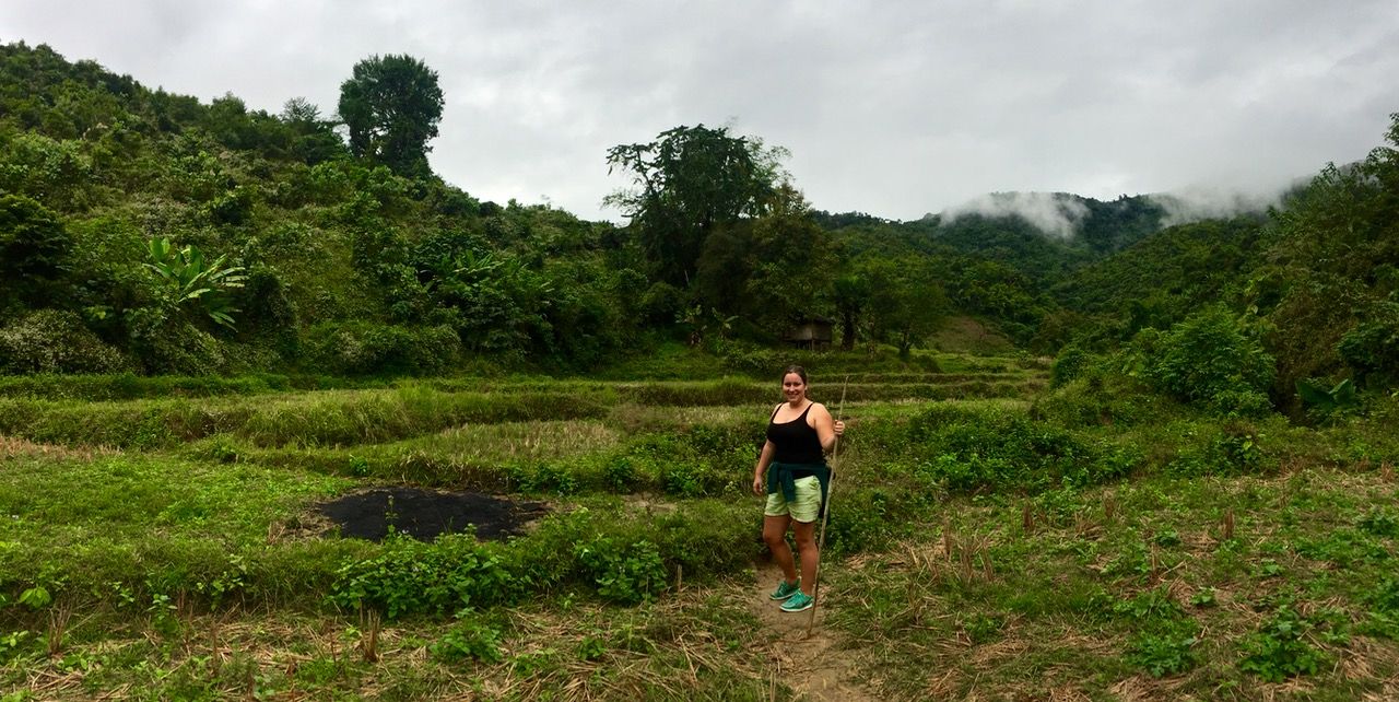 Woman standing in a jungle clearing.
