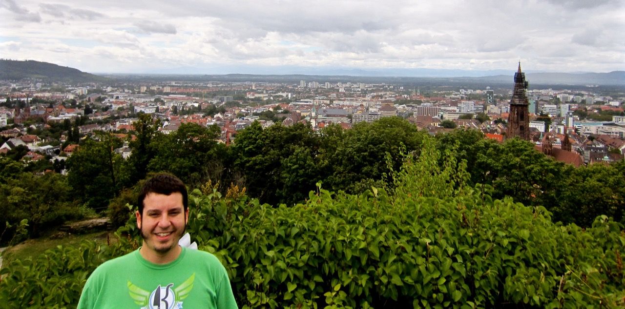 Chris smiling into camera with the city of Freiburg in the background.