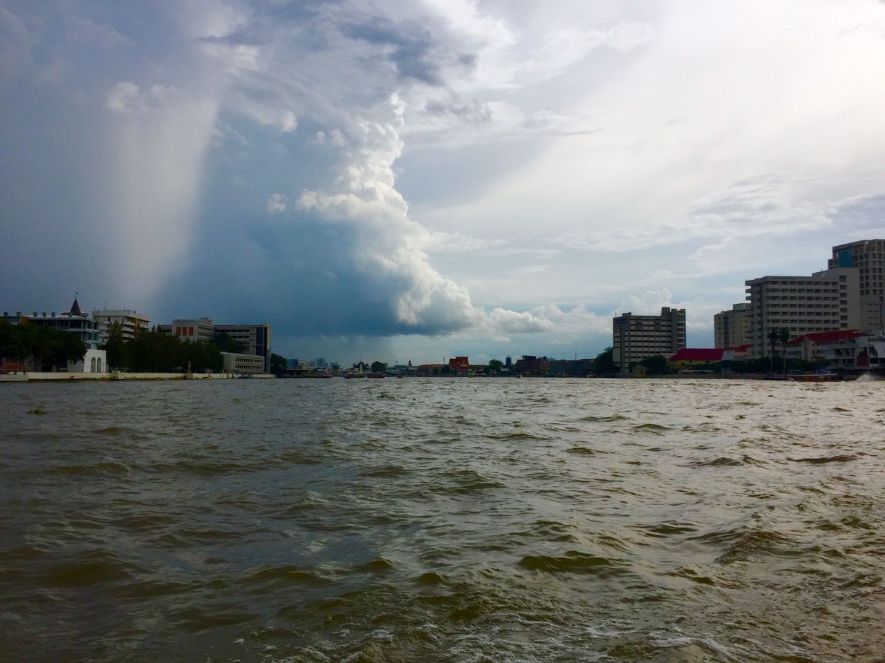 A large rain cloud above a river.