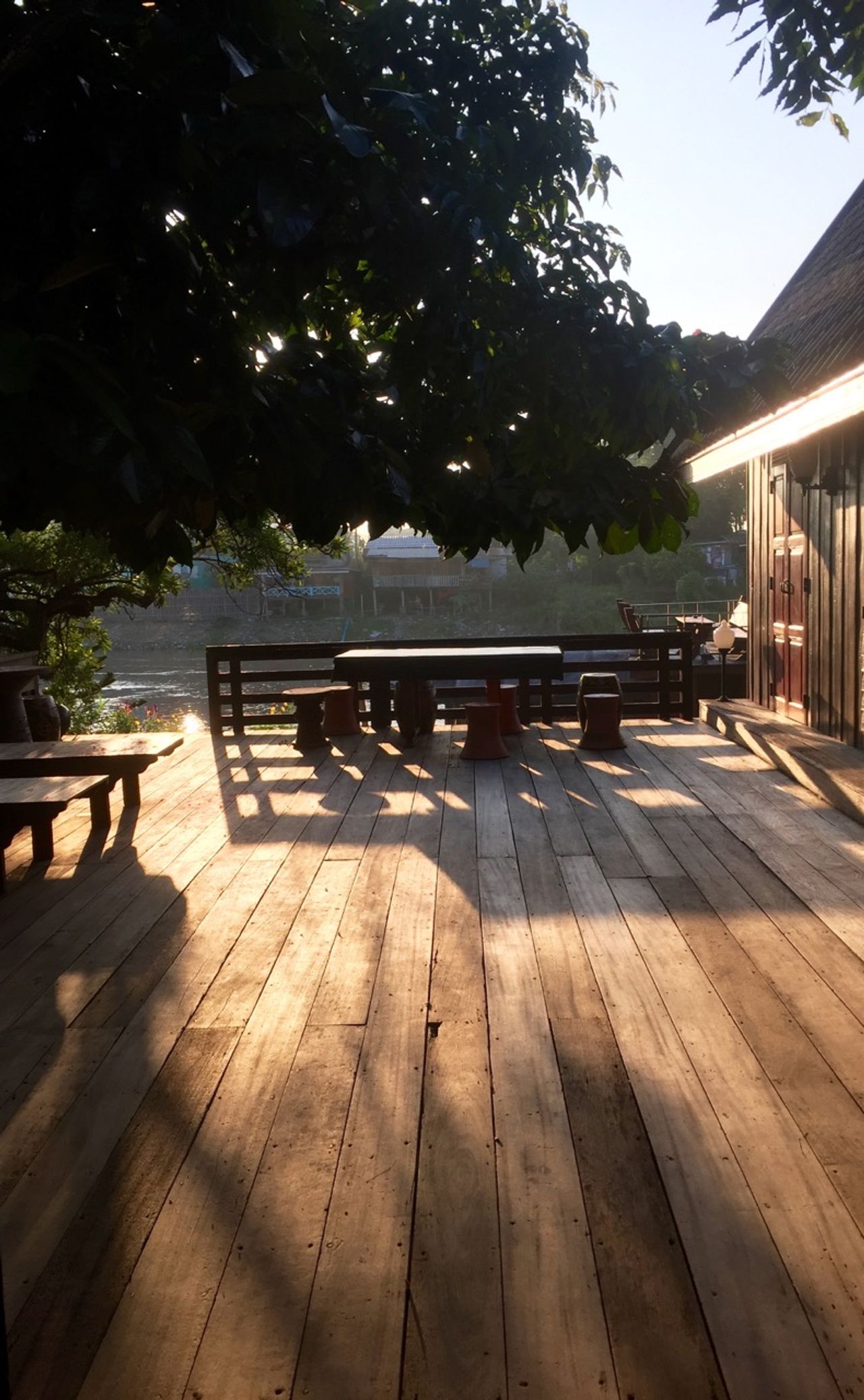 Morning sun shining on a dark teak wood deck.