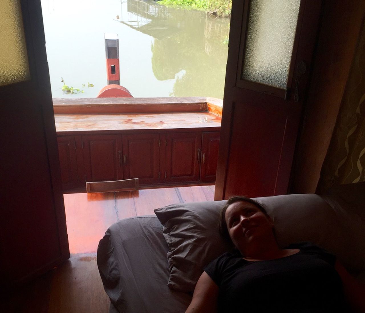 Woman laying on a bed in a boat house.
