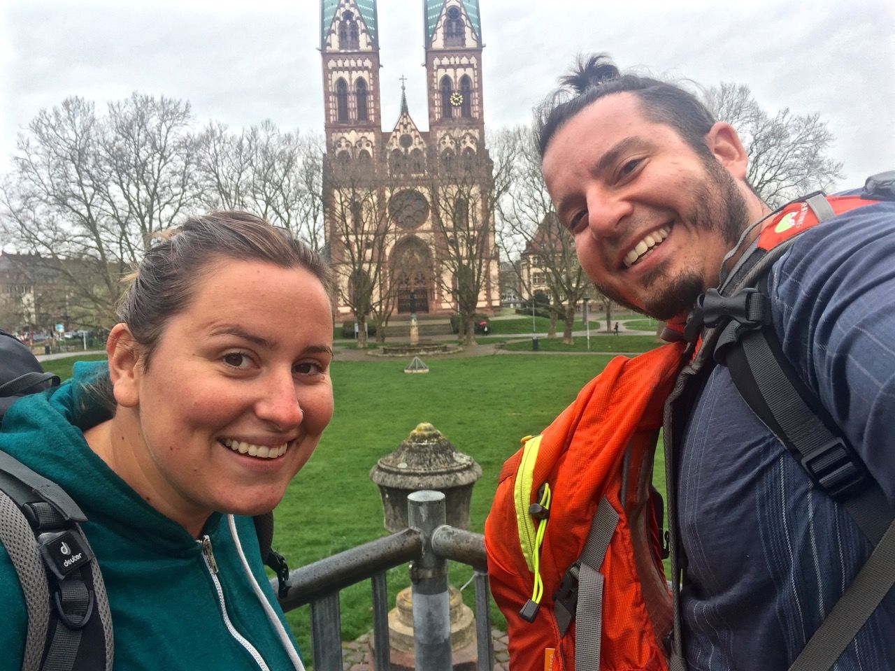 Two people smiling at the camera with a church in the background.
