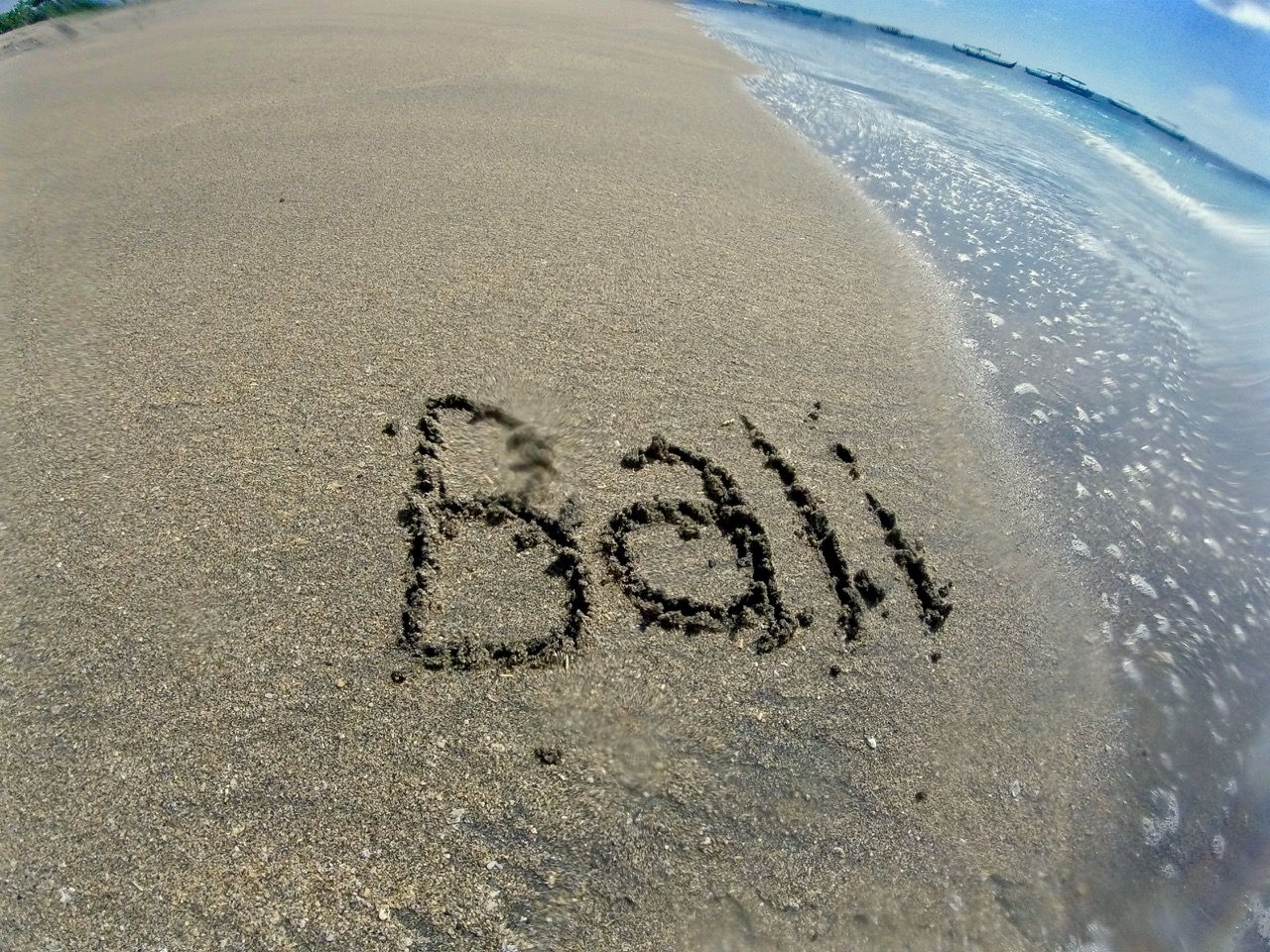 The word "Bali" written in the sand.