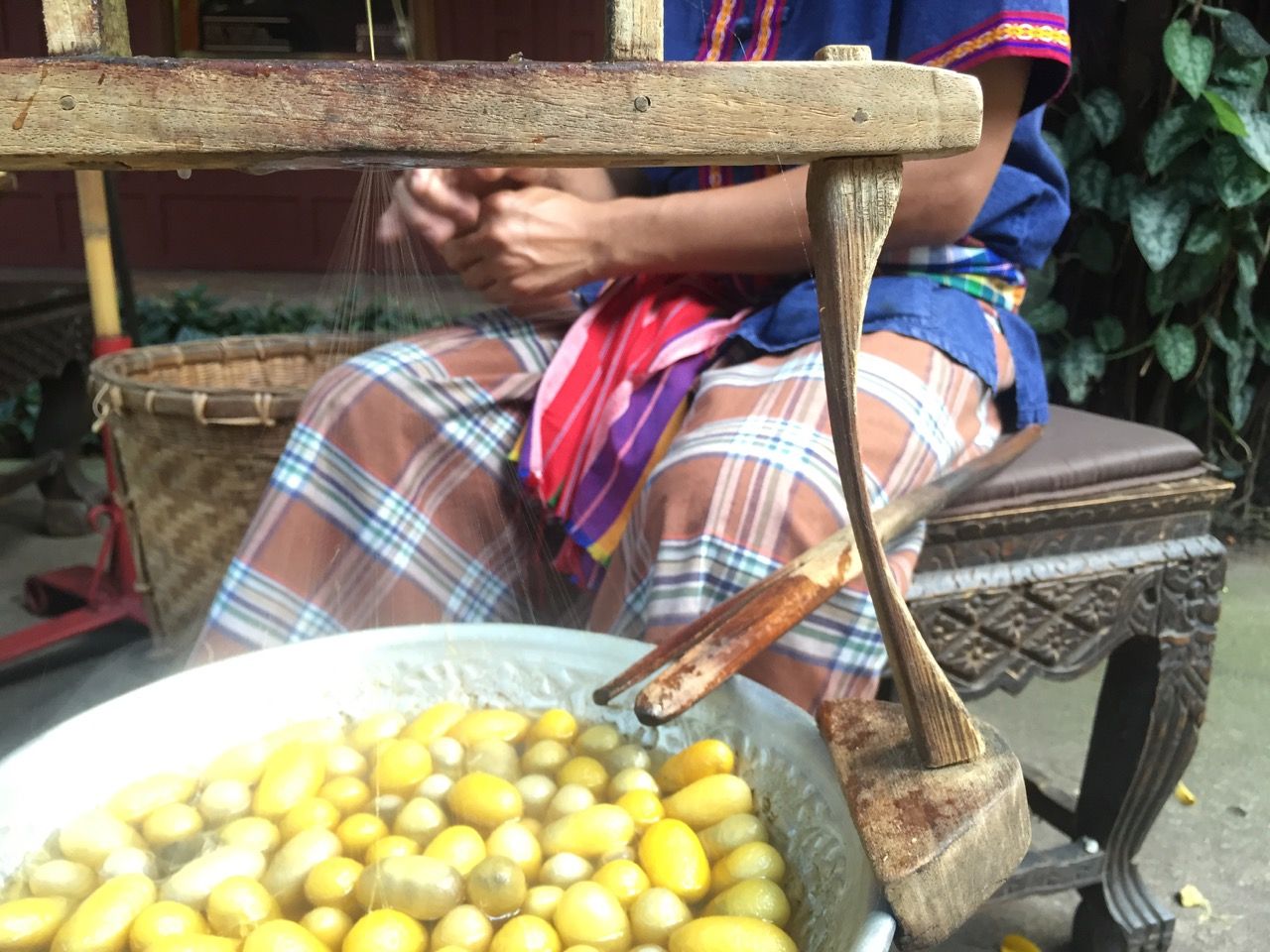 Man spinning silk using traditional methods.