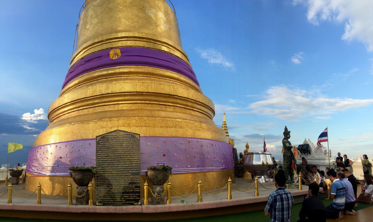 The Golden Mount wrapped with a decorative fabric, surrounded by people.