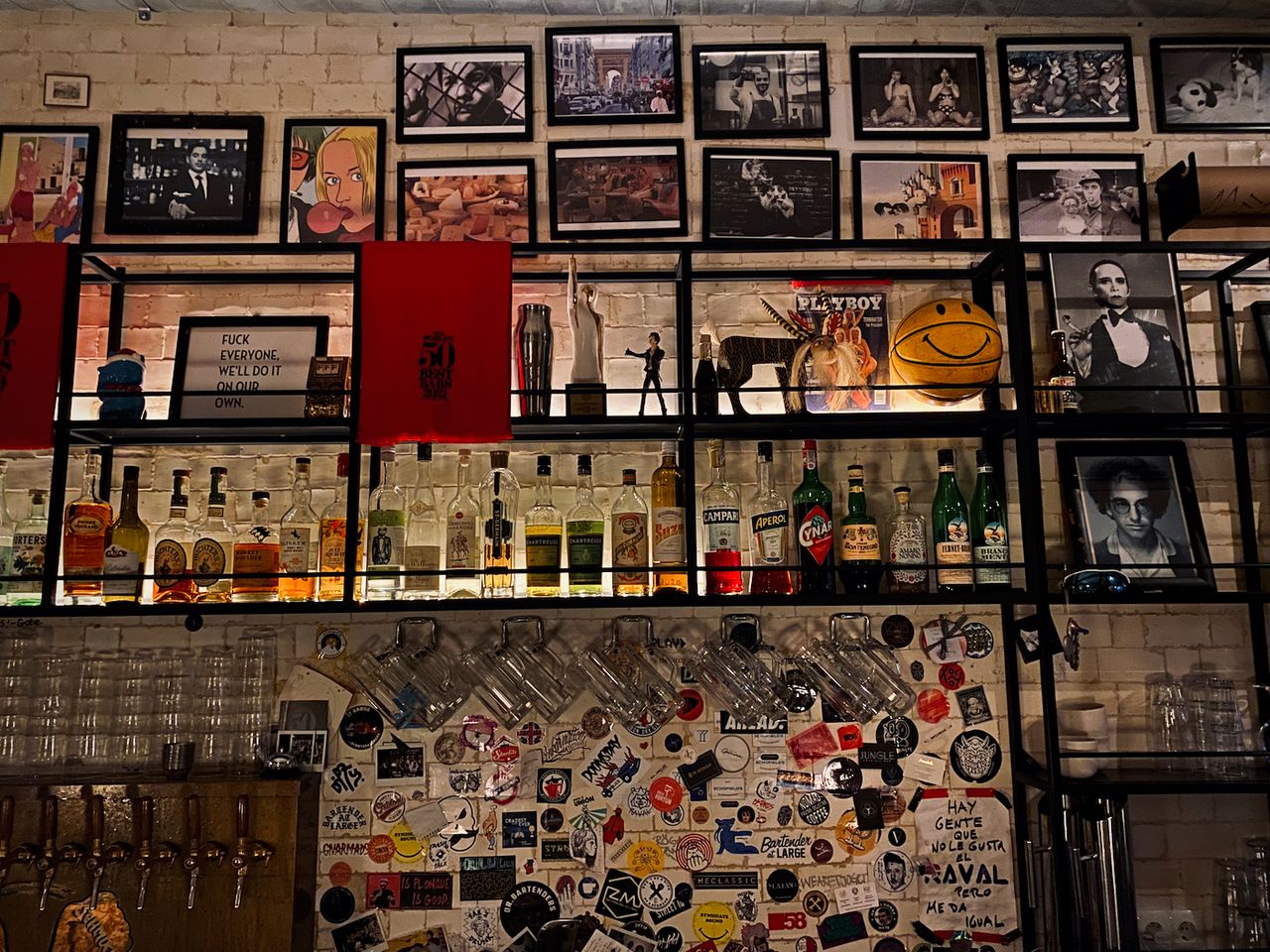 A bar's back wall covered in barware and framed photos.