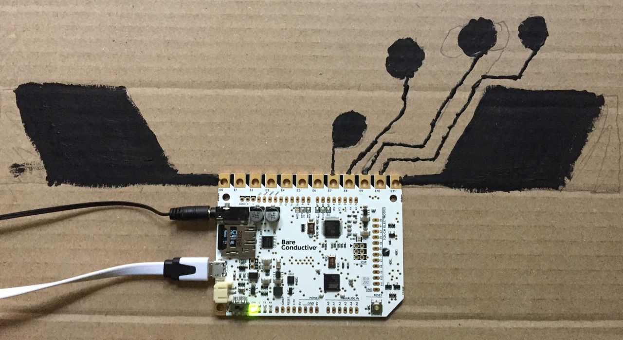 Bare Conductive board with basic pads painted on a piece of cardboard.