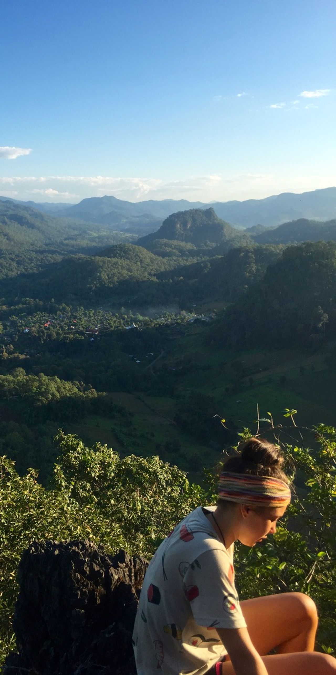 Woman sitting on mountaintop.