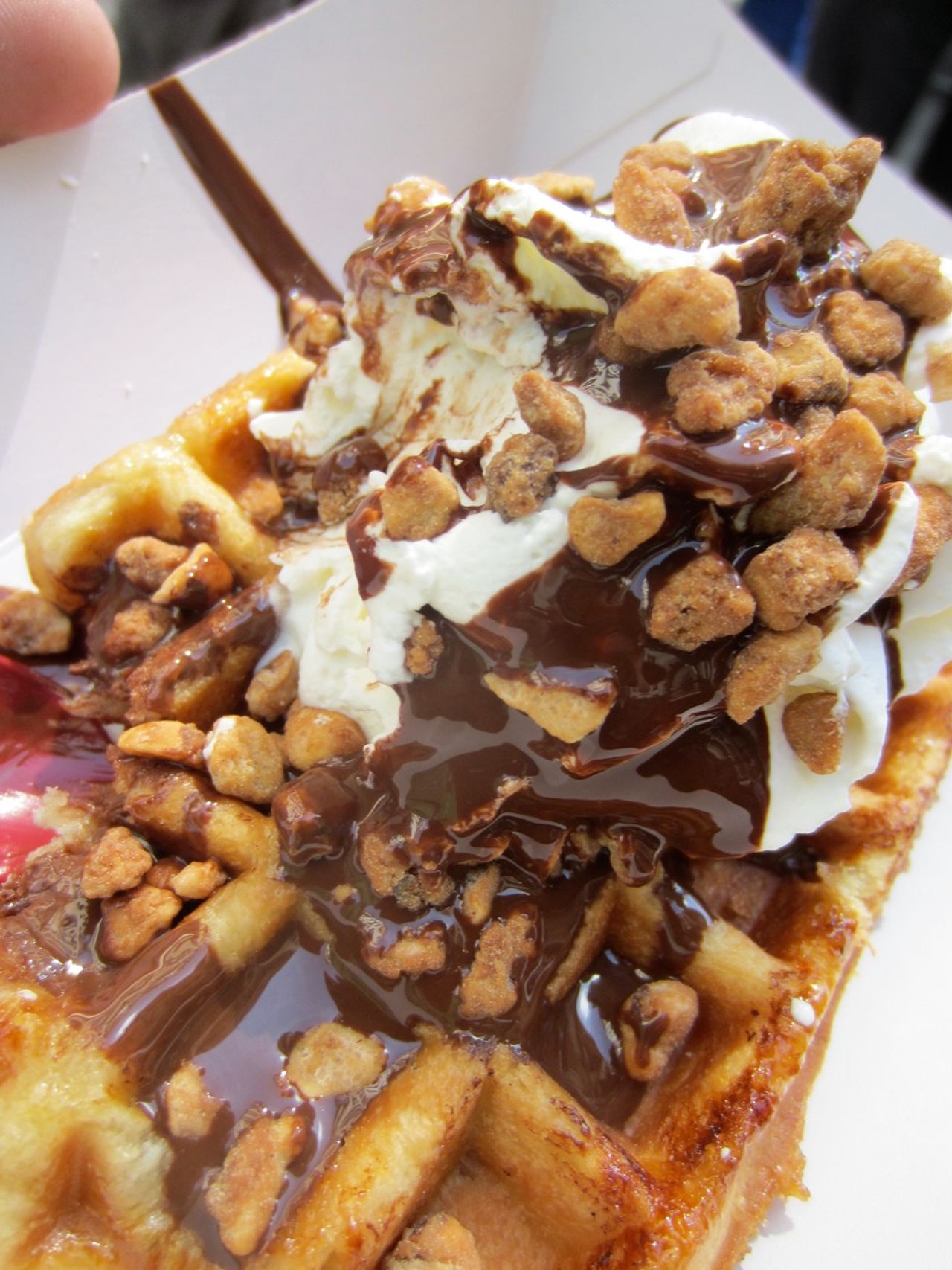 A belgian waffle with cream and other toppings.