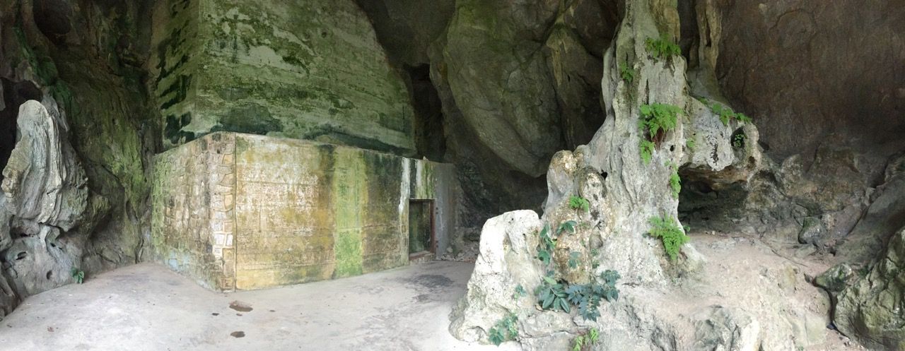 Man-made stone walls embedded into a natural mountainside cave.