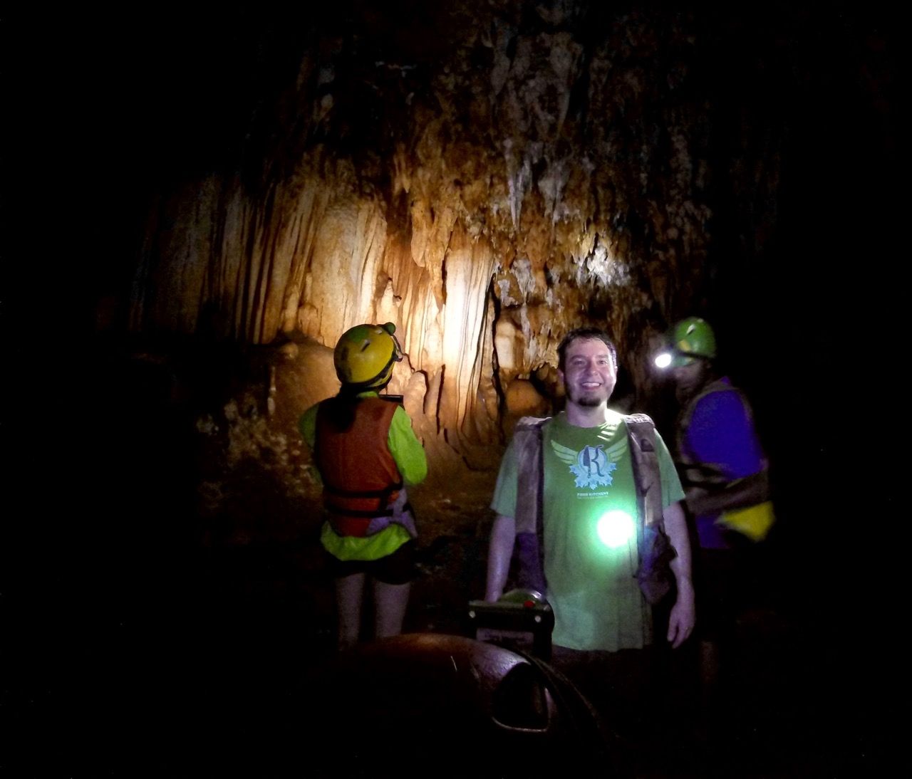People looking at cave formations with one man smiling at the camera.