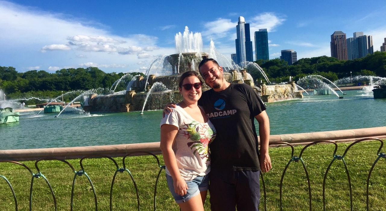 Couple smiling in front of Buckingham Fountain.