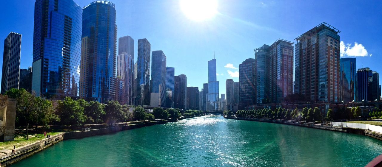 Panoramic of Chicago river, lined with sky scrapers.