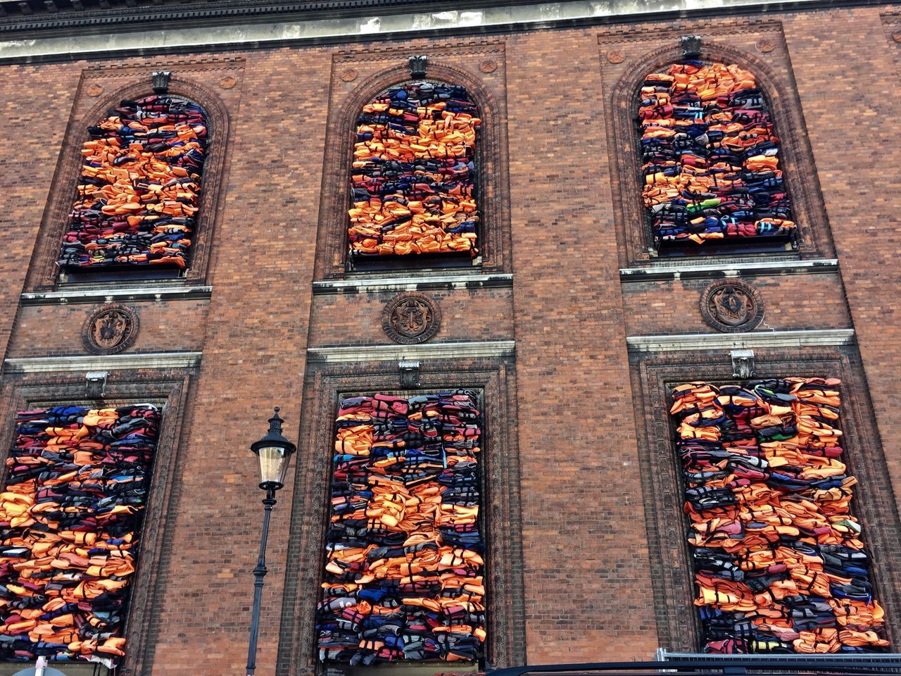 Lifejackets filling the windows of an old building.
