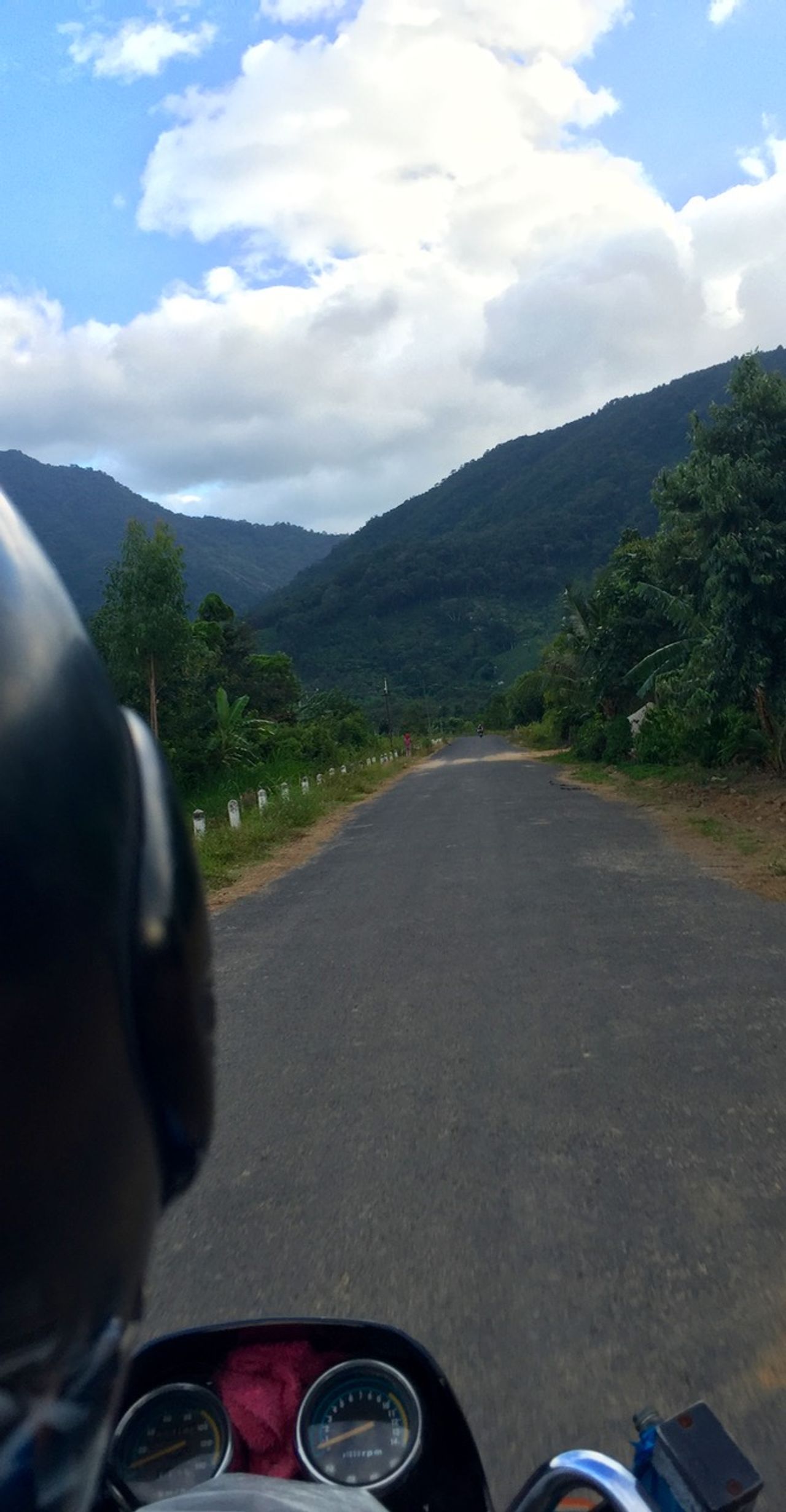 The view from the back of the motorbike as it heads toward mountains.
