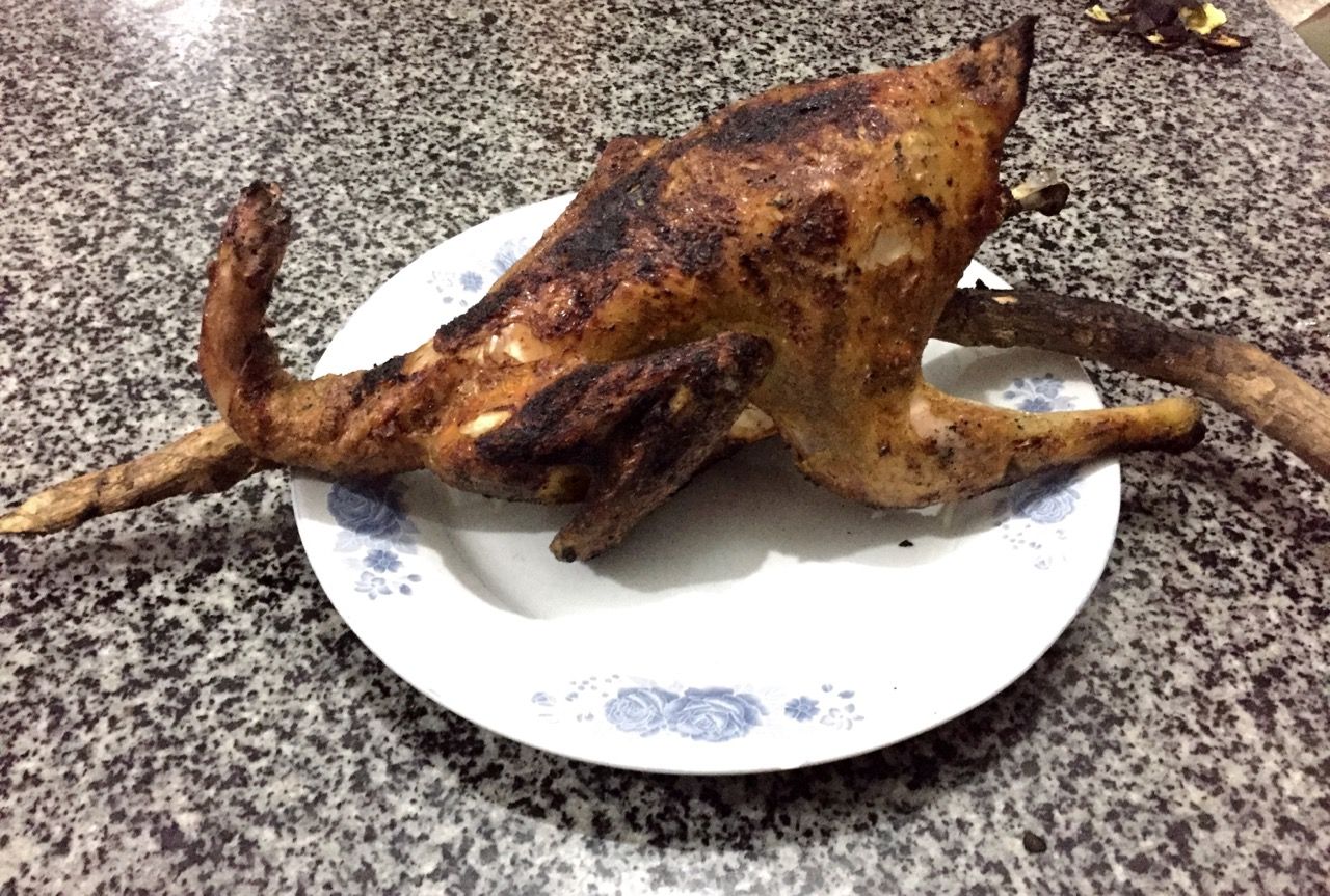 A roasted chicken with a branch still sticking through it.