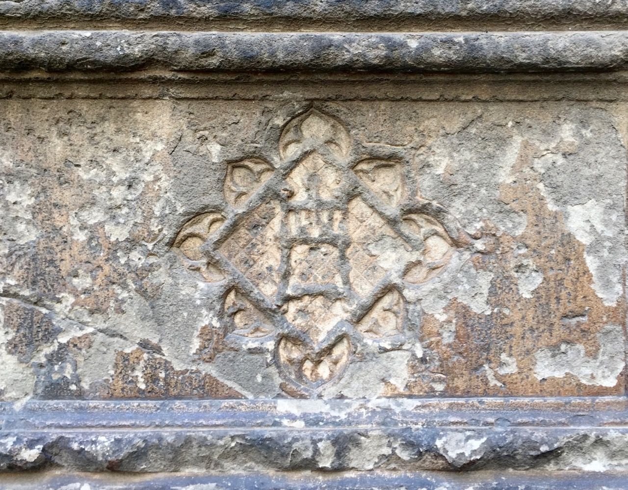 A church seal carved into stone and weathered from time.