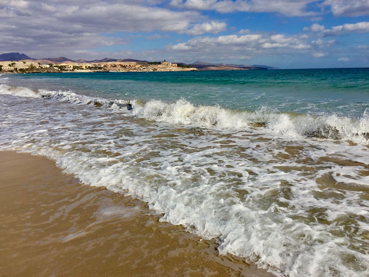 Small waves crashing onto the beach.