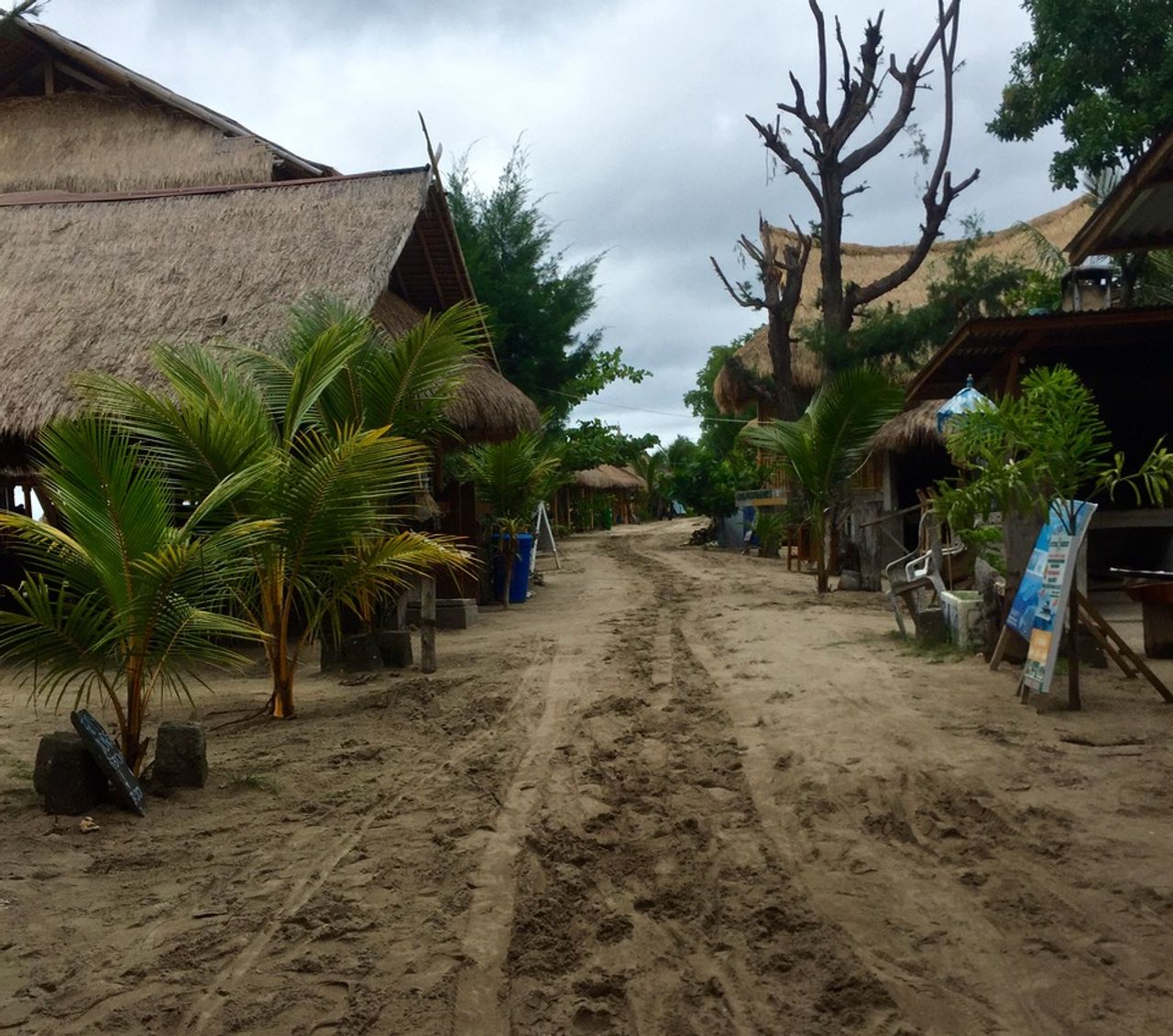 A sand road with bars and restaurants on both sides.