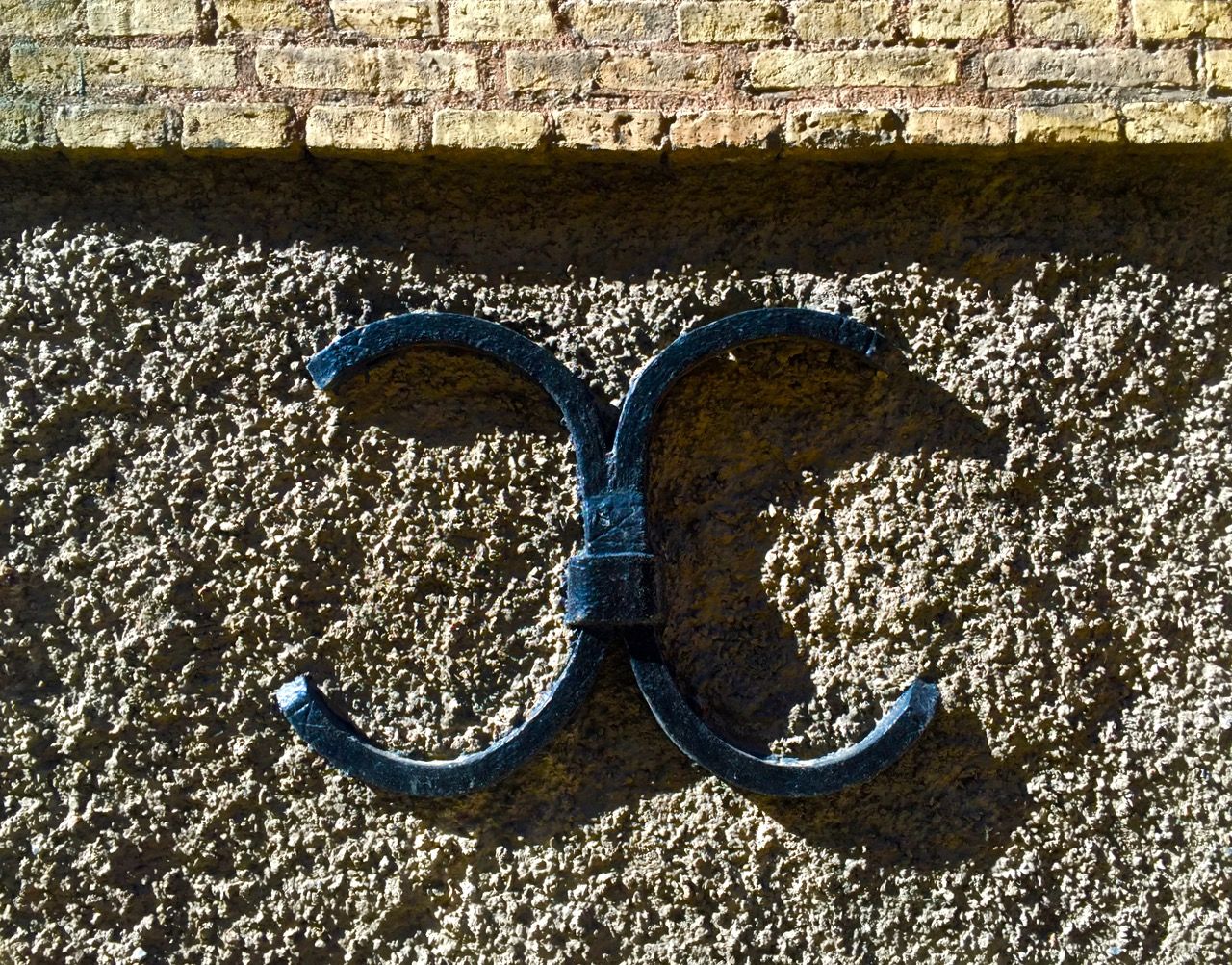 Metalwork on the side of a brick building.