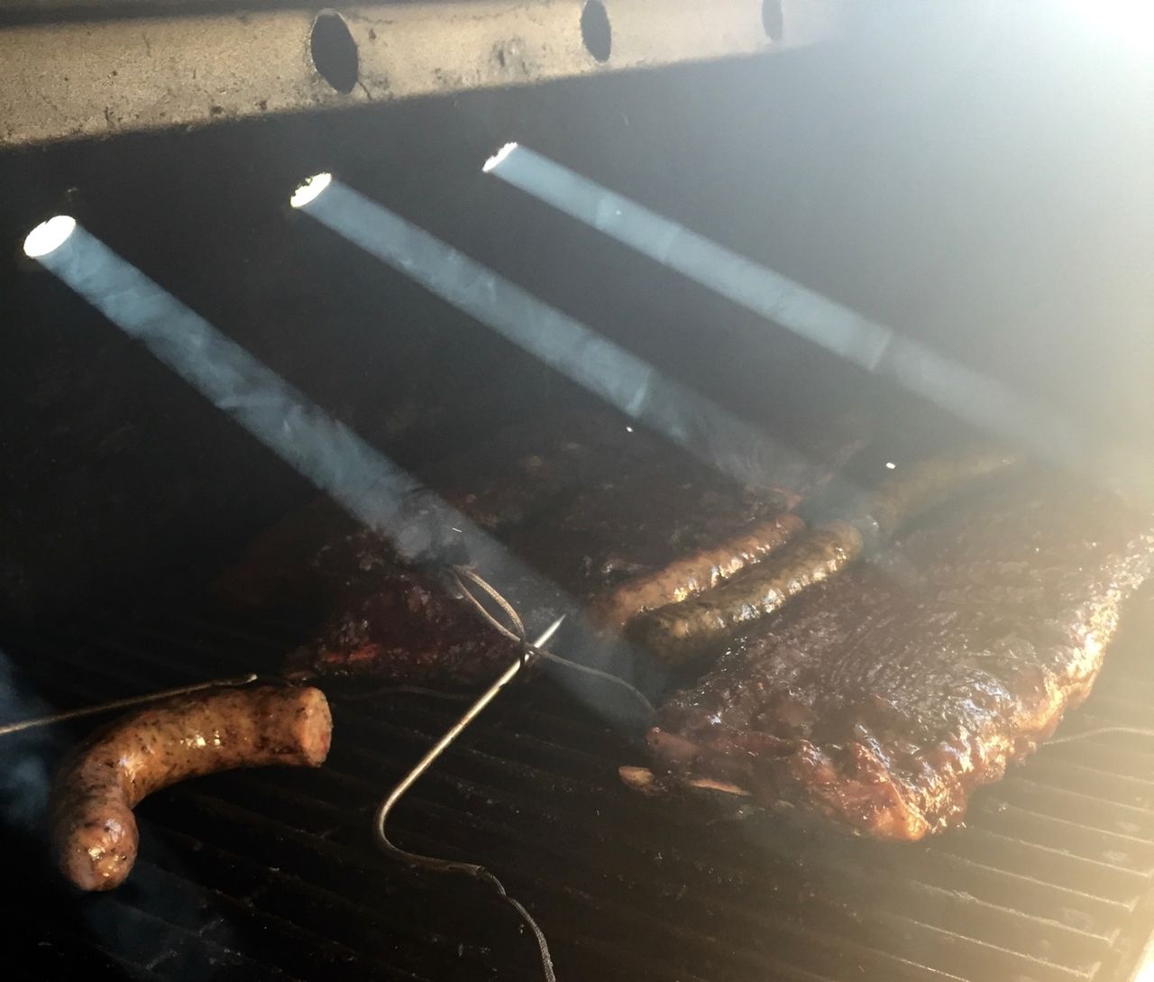 Smokey air with rays of sunlight soming through holes in the smoker.