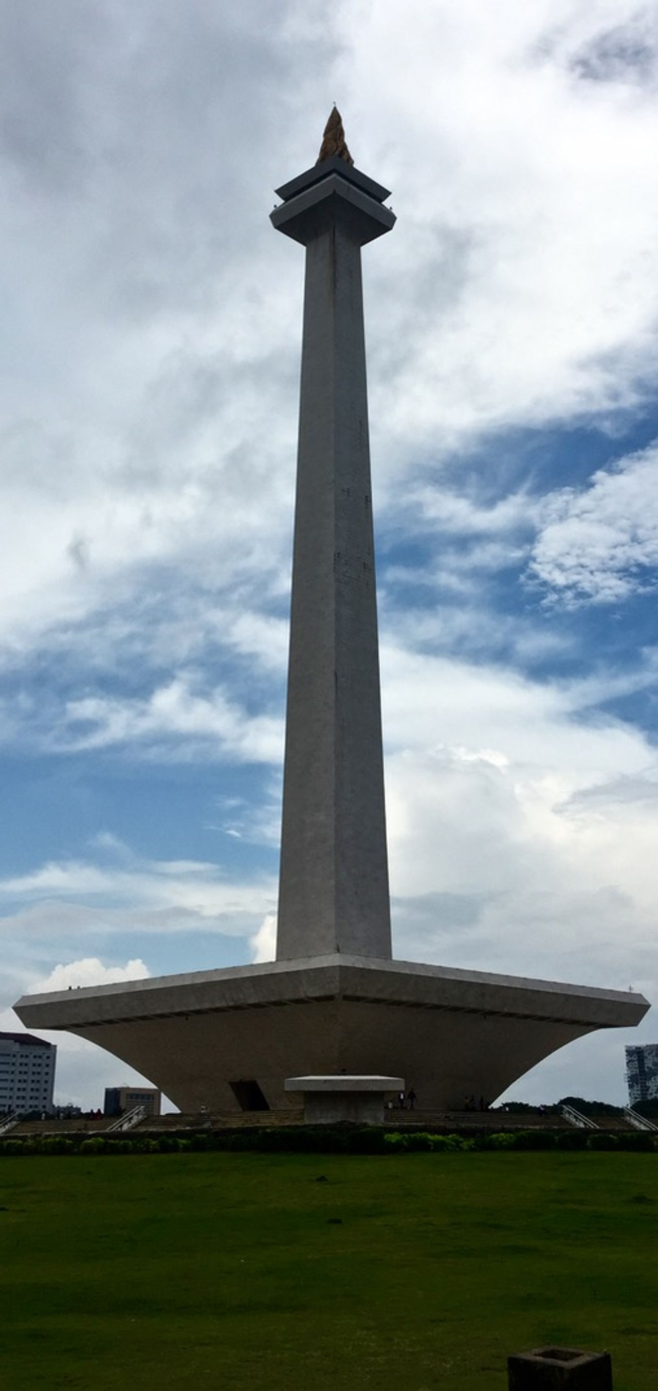 Tall obelisk monument in a grass field.