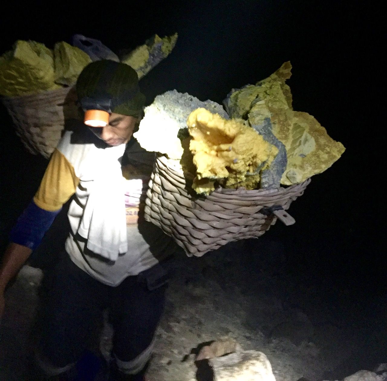 A worker carrying raw sulphur on his back.
