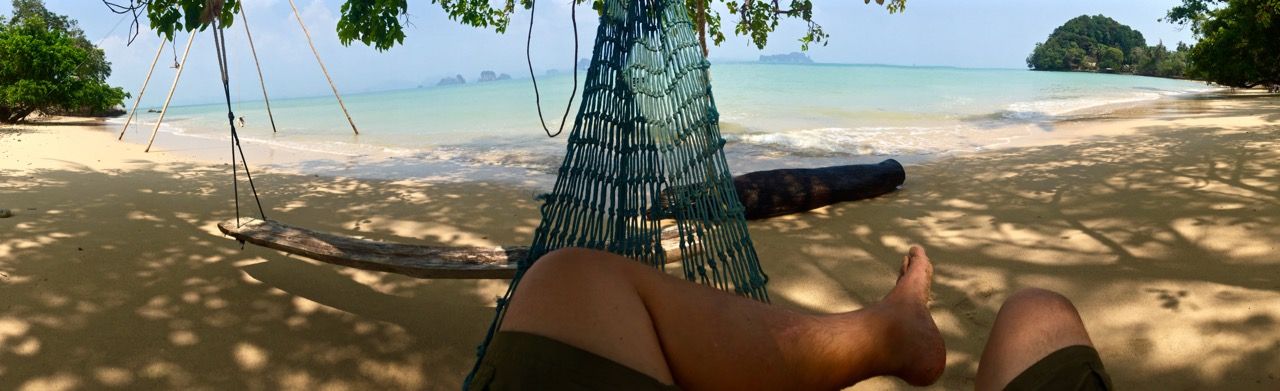 Panoramic of the beach and ocean from inside a hammock.