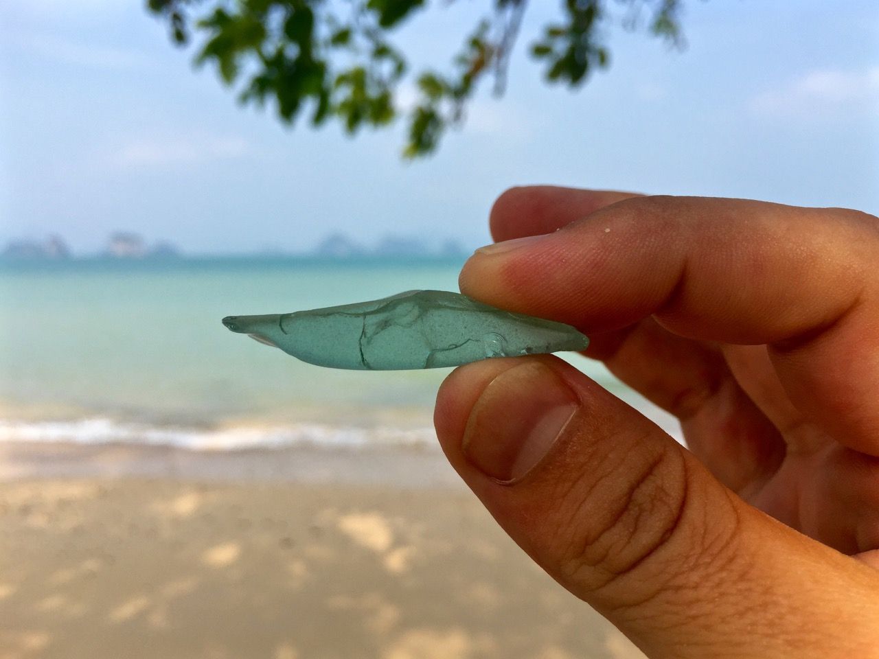 Sea glass whose color matches the ocean in the background.