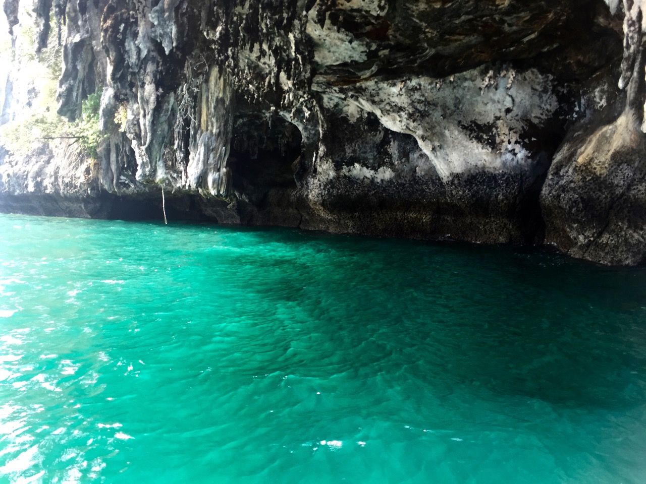 Brightly illuminated water under a cave formation.