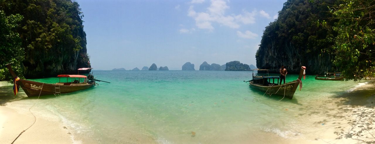 Panoramic of two small boats anchored at the beach.
