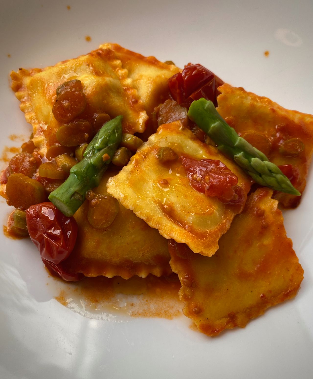 Ravioli with red sauce and green asparagus.