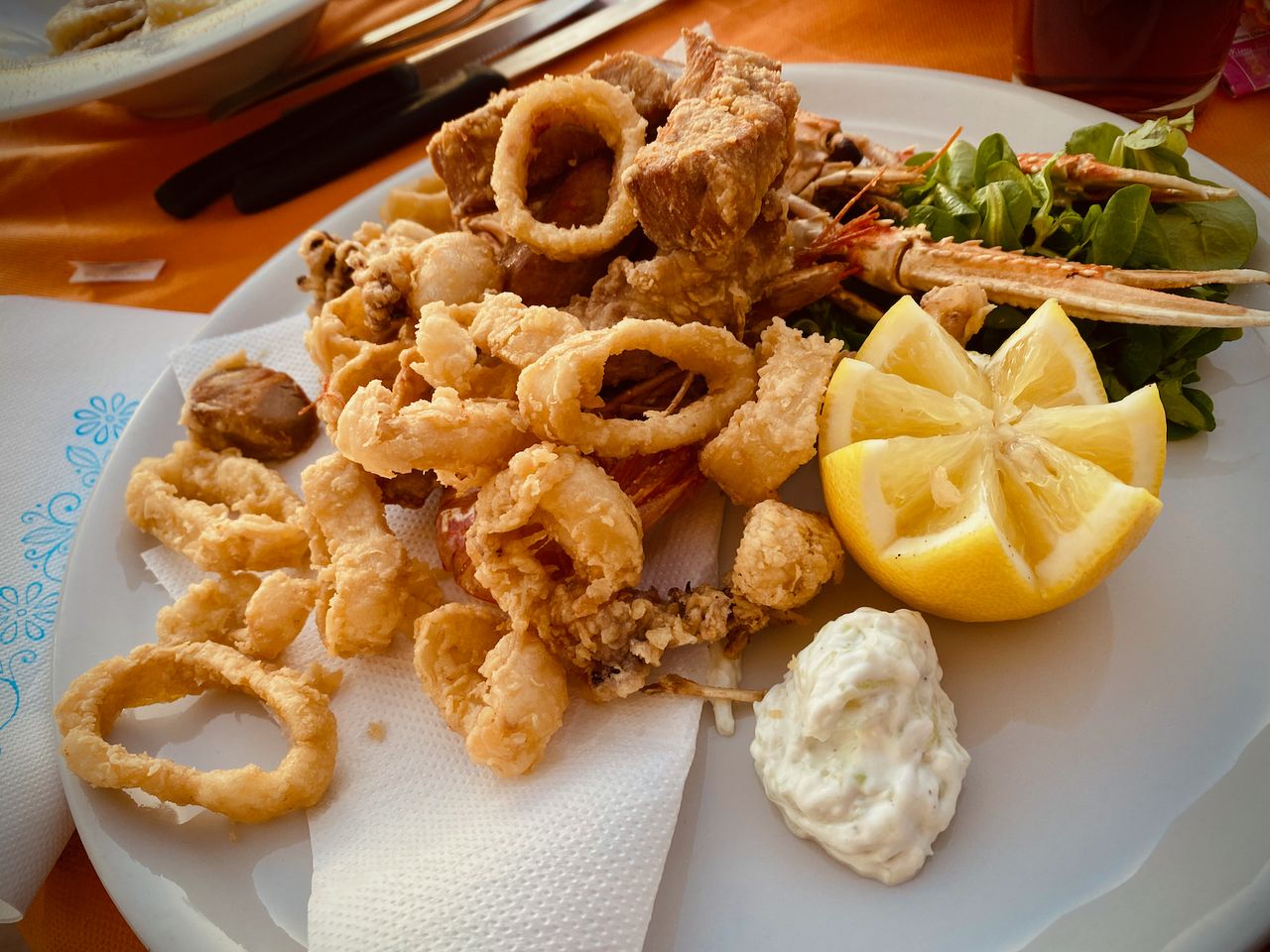 A plate of fried seafood with a decorative lemon.