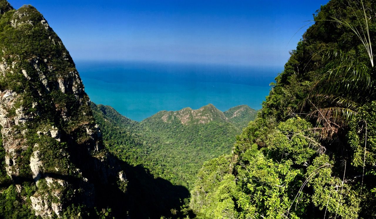 Panoramic of ocean between two mountains.