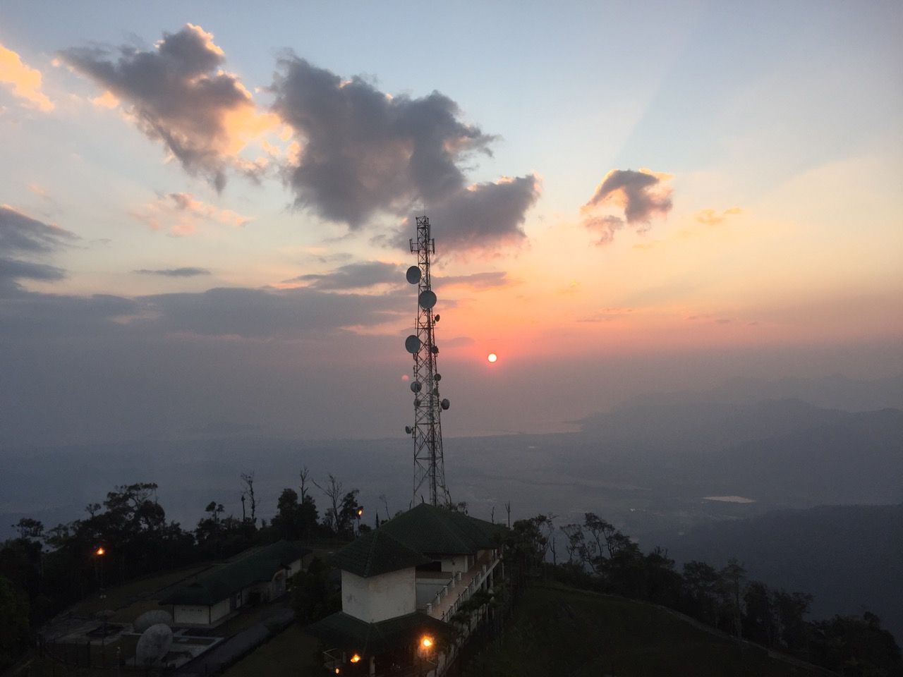 Sunset from on top of a mountain with a TV tower in foreground.