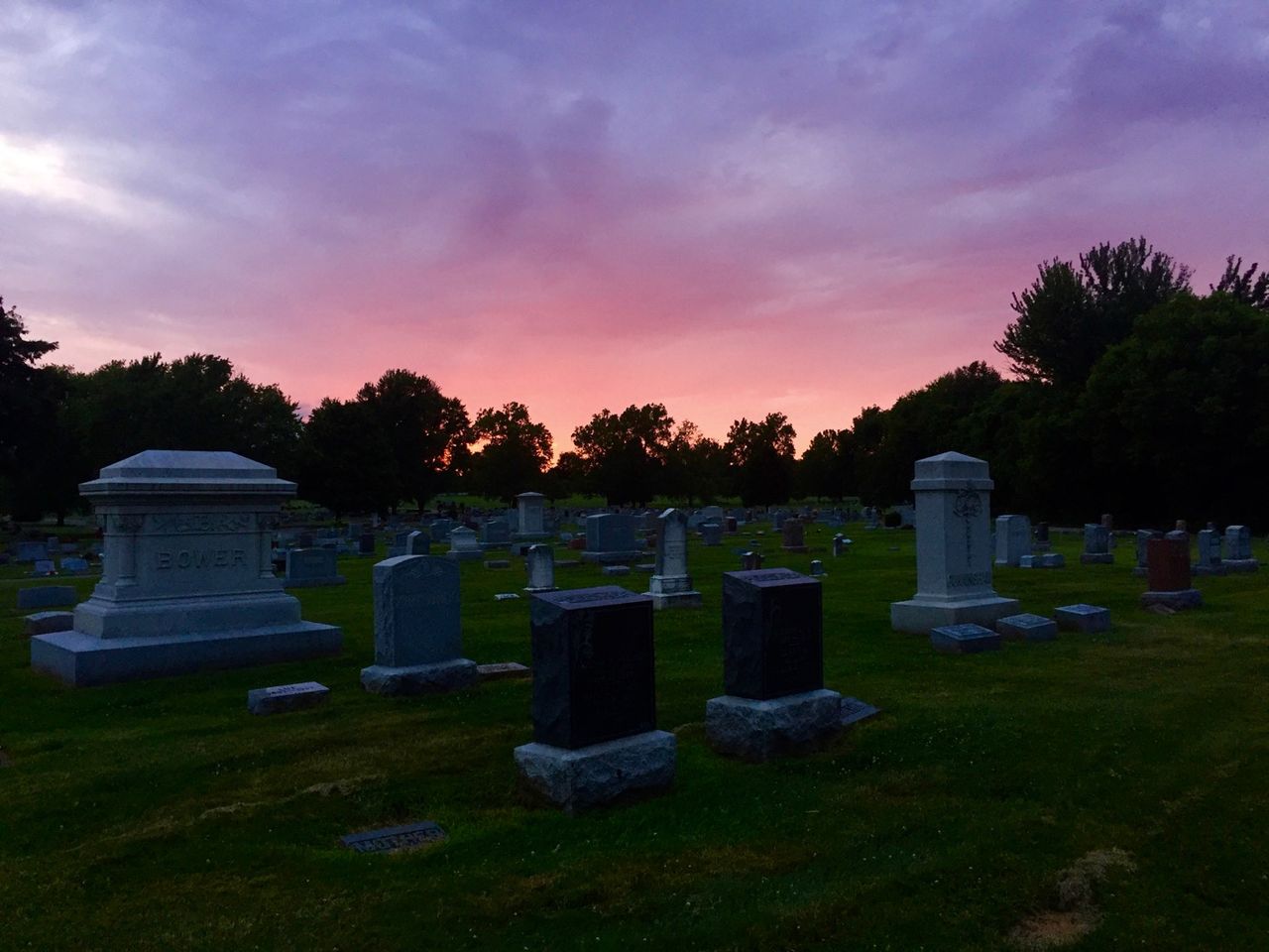 Pink and orange sky over a field of headstones.