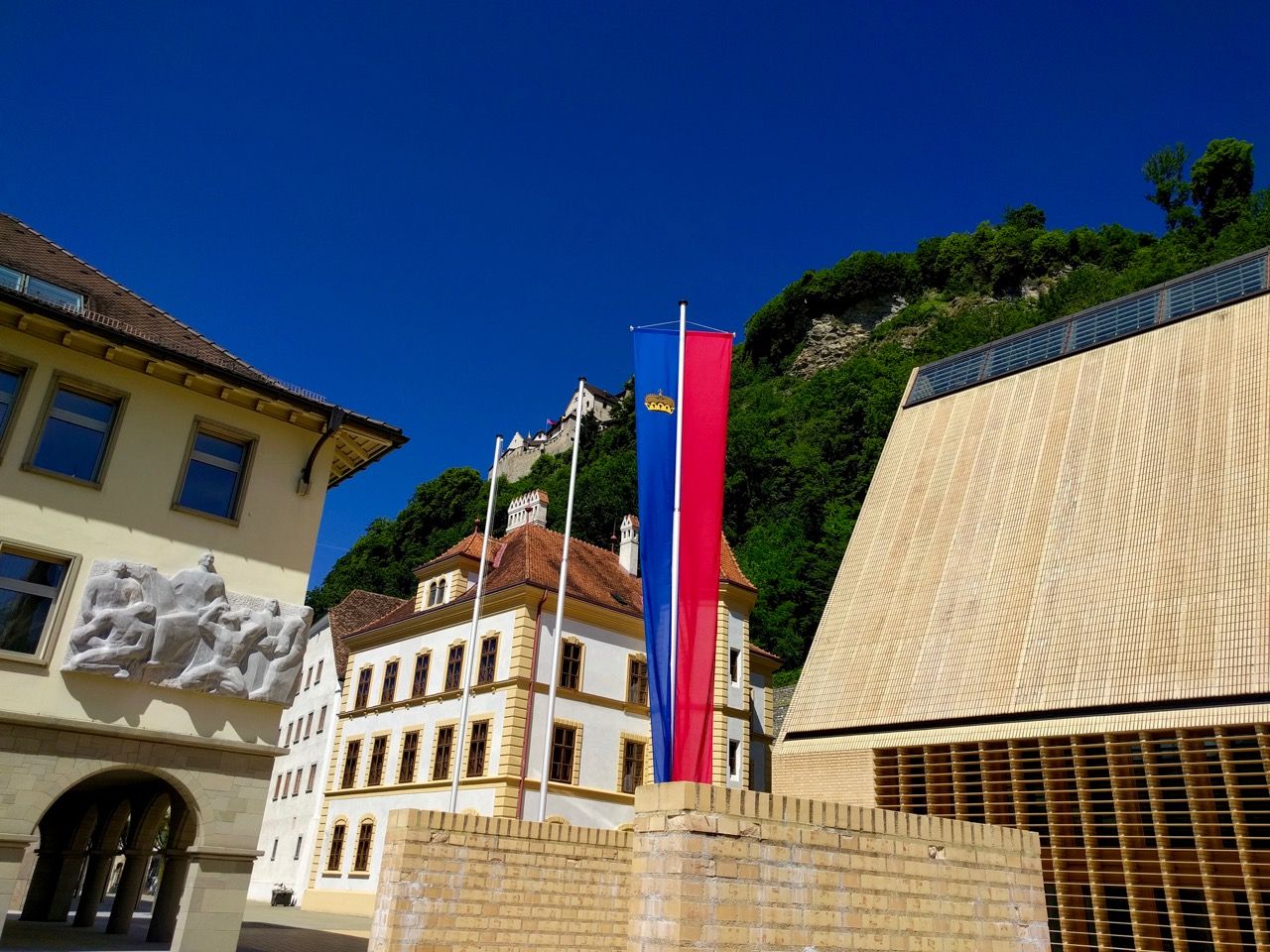 Parliment building of Liechtenstein with a flag in the foreground.