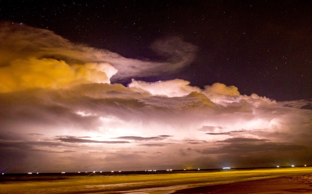 Long exposure of a lightning storm at night on the beach.