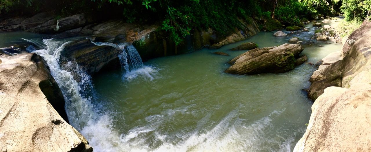 Panoramic photo of a waterfall pool.
