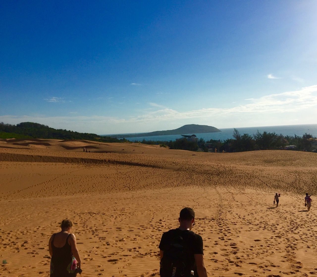 People walking on the red sand dunes.