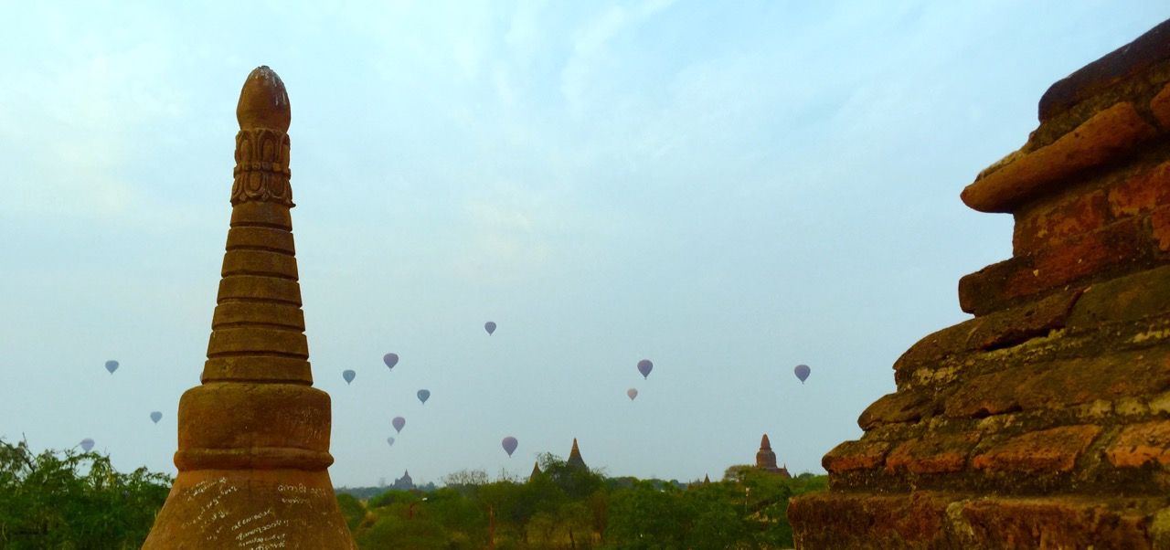 Balloons rising over the horizon with temples in foreground.