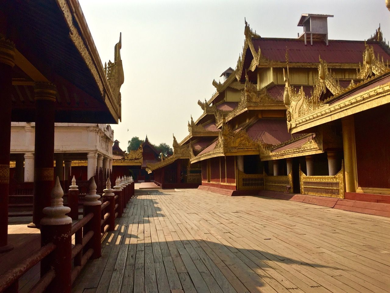 A long empty corridor lined with royal buildings.