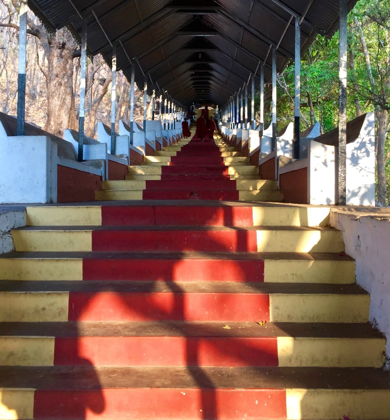 Red and gold painted stairs leading visitors up Mandalay Hill.