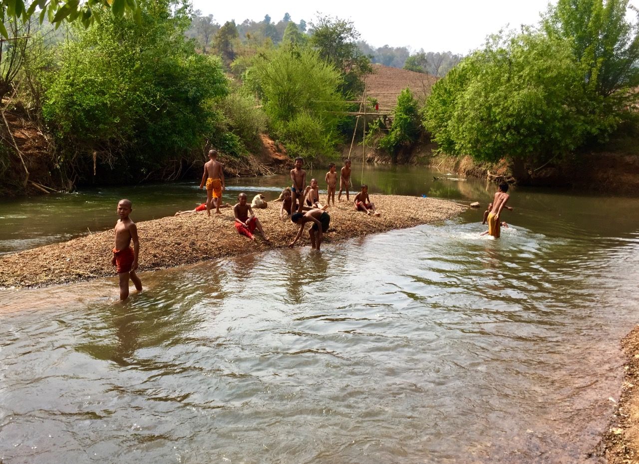 Young boys playing on a river bank.