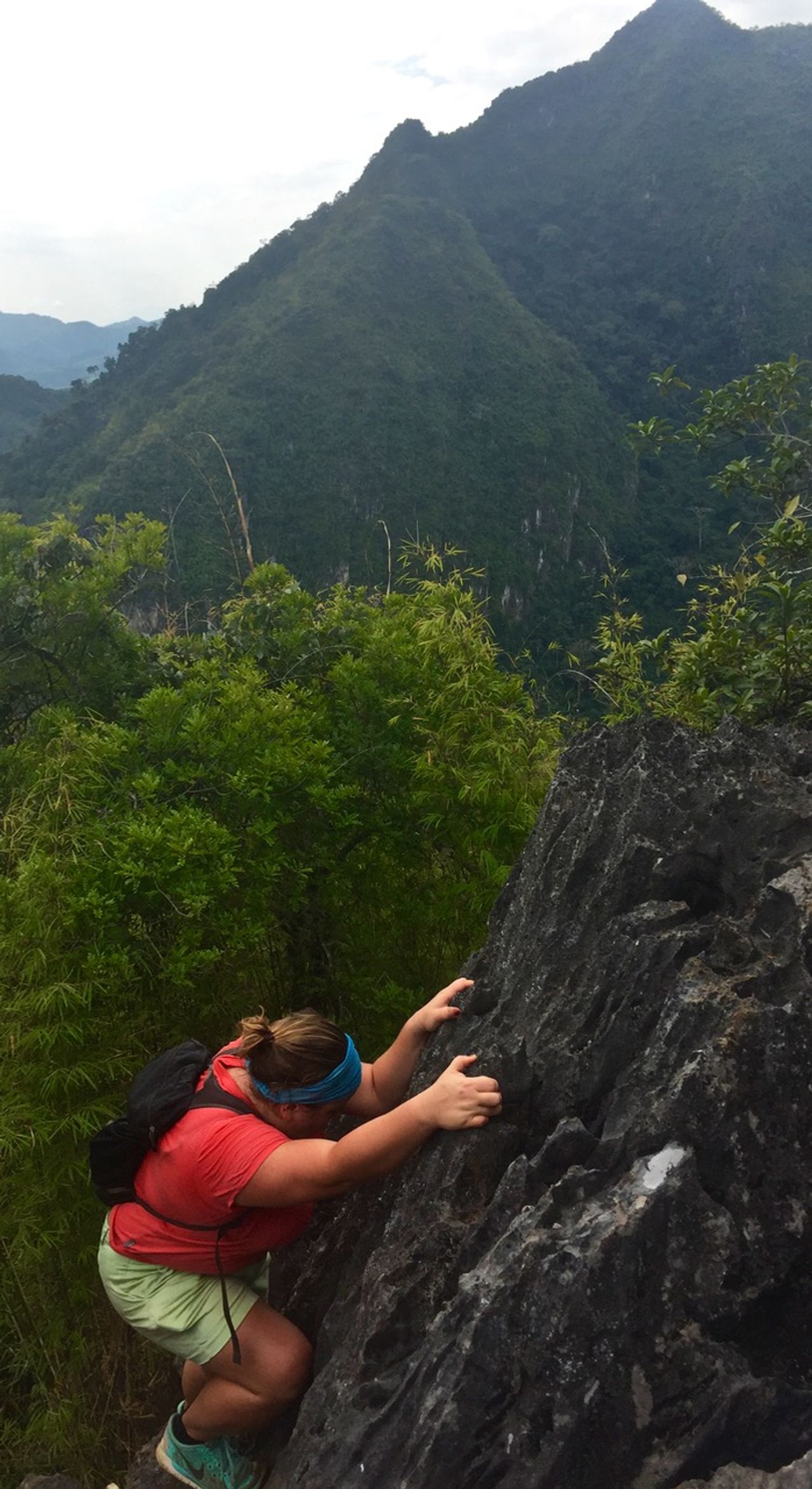 Woman climbing down sharp rocks.