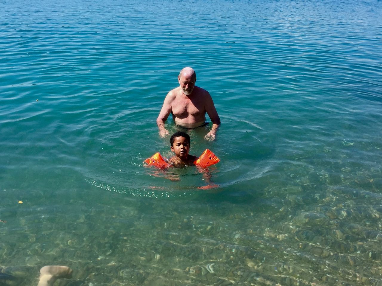 Man and boy swimming in water.