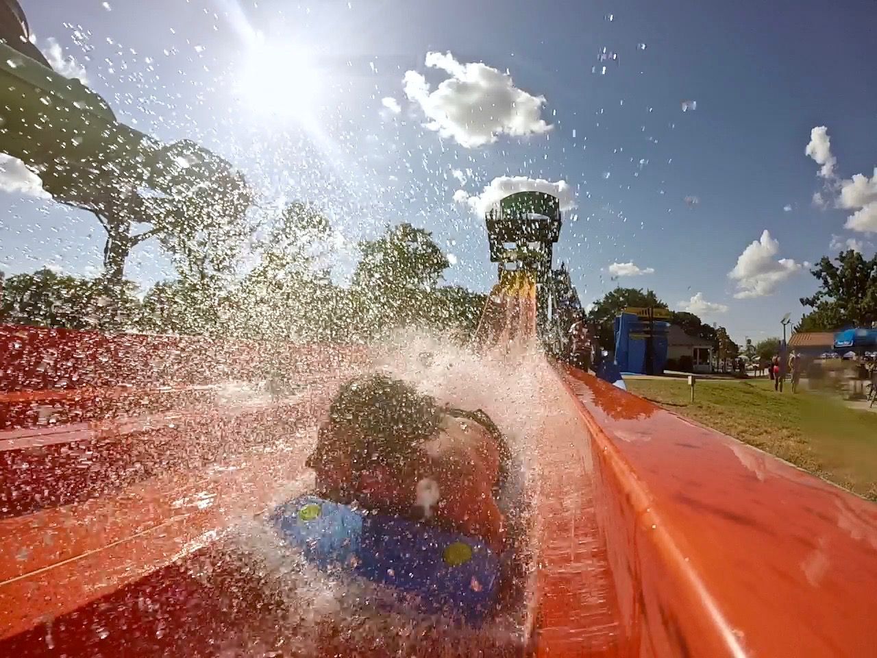 Man making huge splash on a water slide.