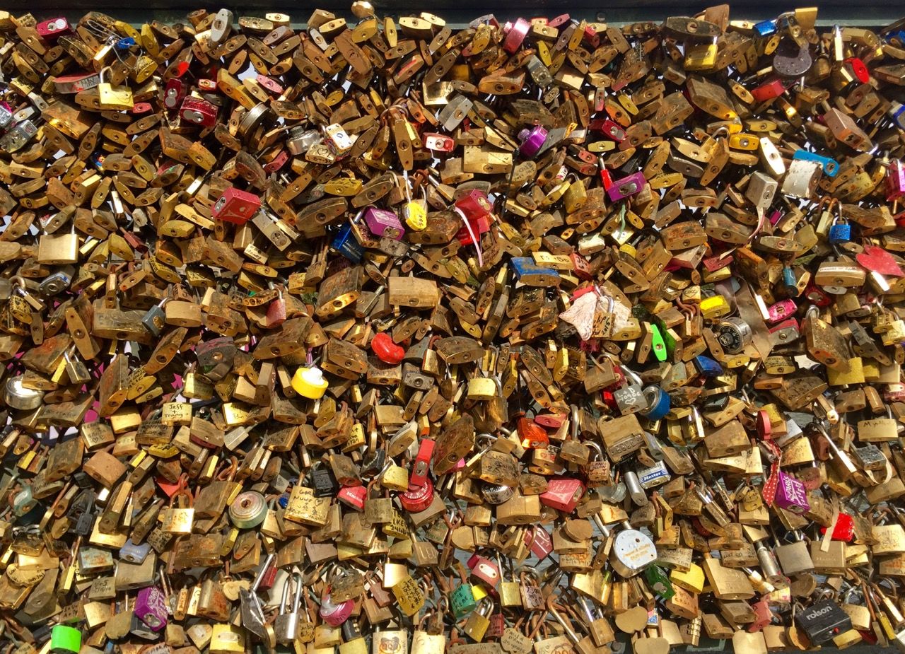Hundreds of padlocks on a chain link fence. The fence is not visible.