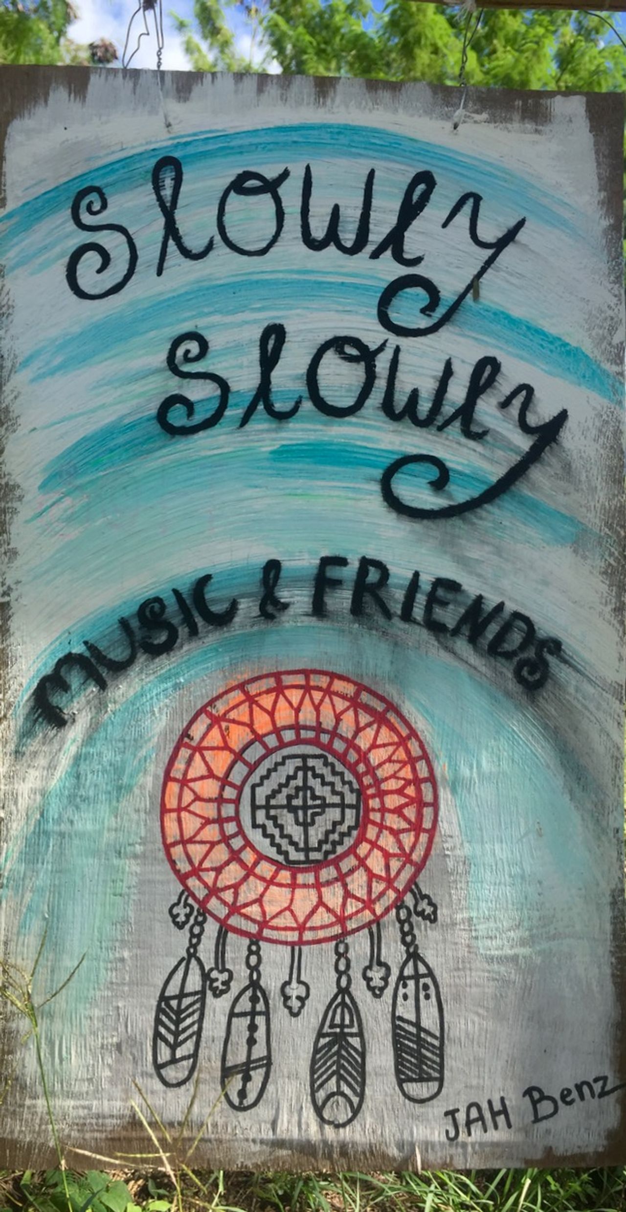 Painting that reads "Slowly, slowly. Music and friends"
