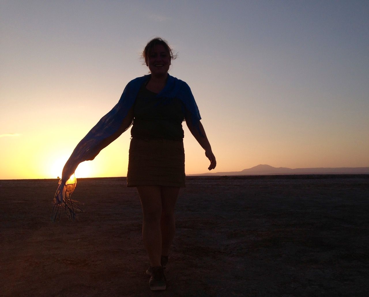 Woman walking in front of sunset.